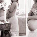 fine art pregnant woman from the side admiring her reflection in a mirror