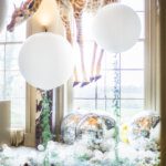 Large white party balloons with a suspended stuffed giraffe at anyhow park