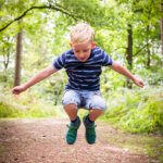 Boy jumping in a wood