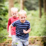 Brothers running through a wood