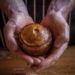 Large hands holding a pork pie