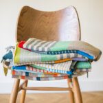 Colourful pile of wristwarmers piled on a vintage wooden chair