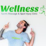 Tattooed masseuse pointing up to his green business sign