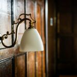 Close up a vintage wall lamp on a wood panelled wall interior