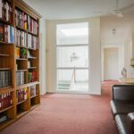 Interior of a business room with long sofas and wall shelves filled with books