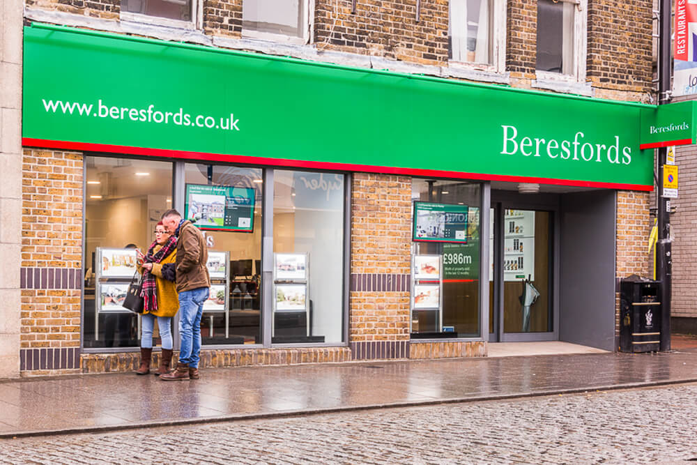 Exterior window of a large estate agents in the rain