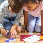 Children  heads together playing a game on the floor with a special torch