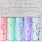 a line up of pastel coloured personalised reusable cups with straws