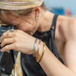 Model using a vintage camera wearing three personalised bangles