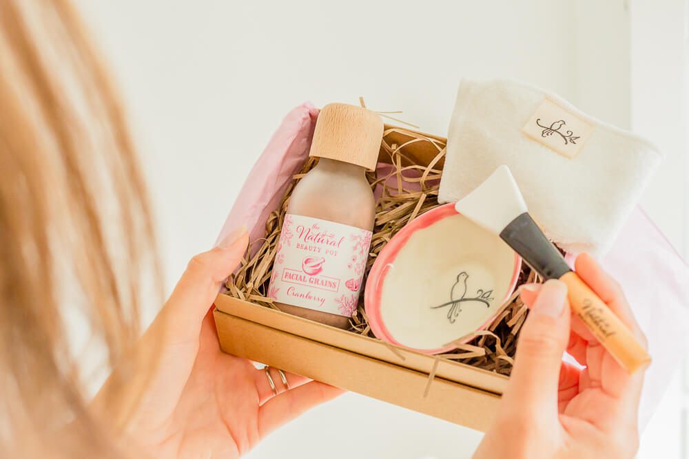 model holding an open box  of beauty products