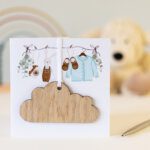 Handmade card with a wooden cloud hanging decoration on the front with a toys in the background