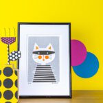 Art print of a cat with bold colour accessories on a yellow background