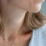 Close up of a model wearing delicate pendant necklace