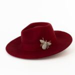 Pack shot of a red felt fedora with bee detail